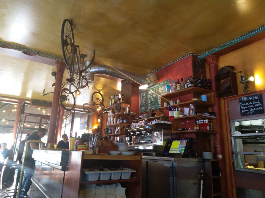 Photo du comptoir d'un café restaurant avec un vélo au plafond